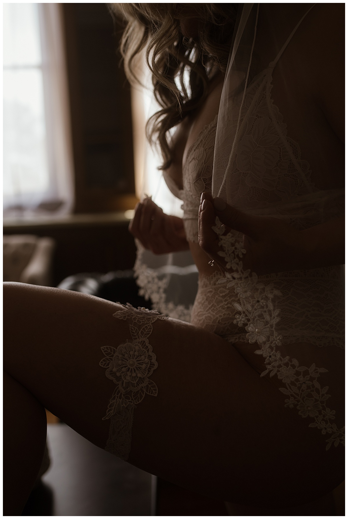 woman tugs at her veil during her Bridal Boudoir session