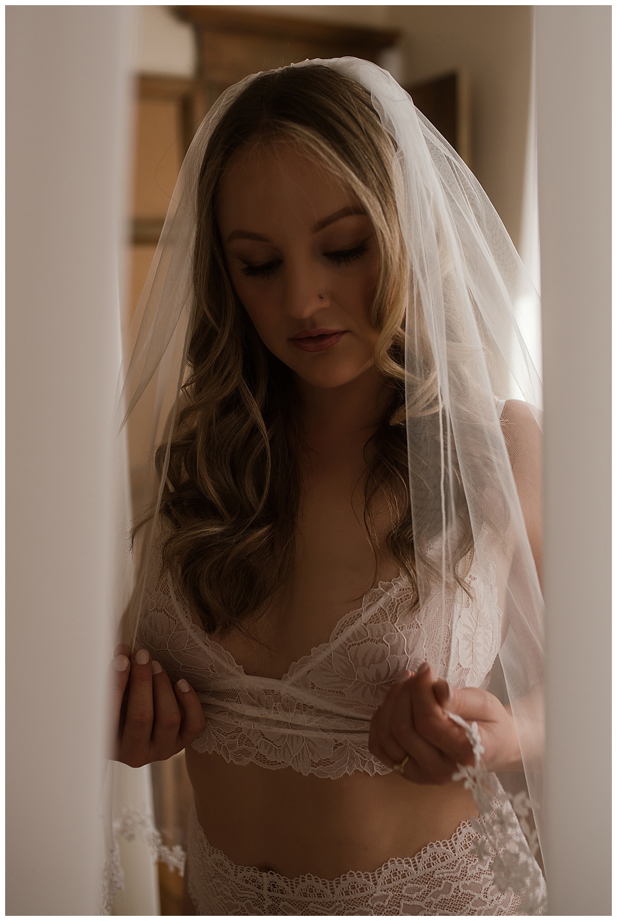 Female holds onto veil where white lingerie for Melissa Brielle Boudoir