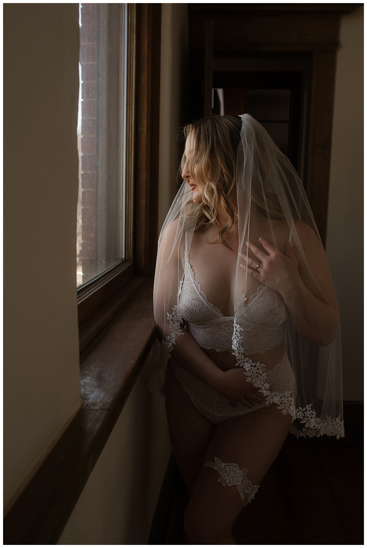 Person stands in front of a window wearing white lingerie for Melissa Brielle Boudoir