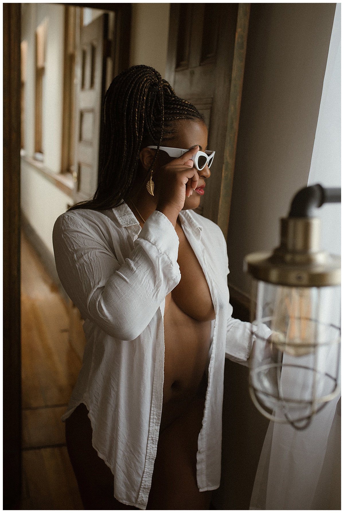 Female holds her glasses and wears a white lingerie shirt for Melissa Brielle Boudoir