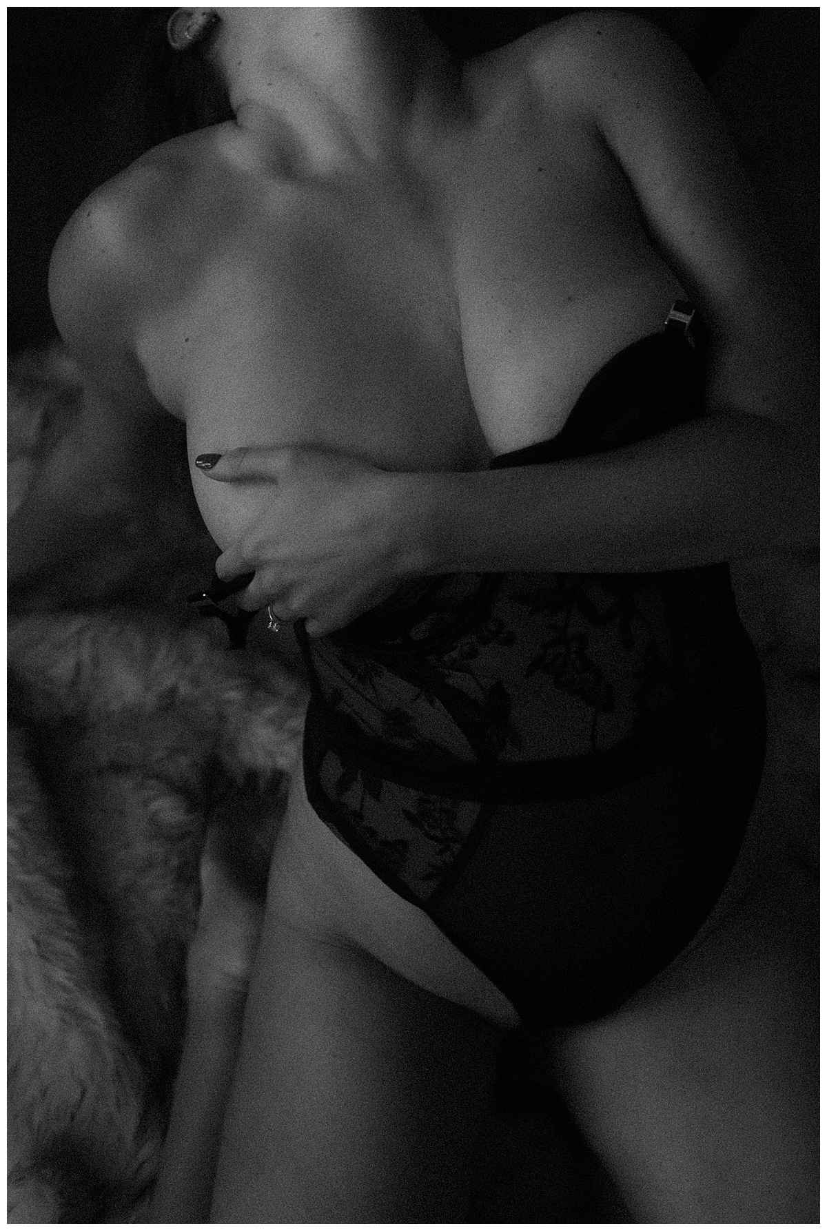 Adult wears black lingerie and covers her chest with her arm for Colorado Boudoir Photographer